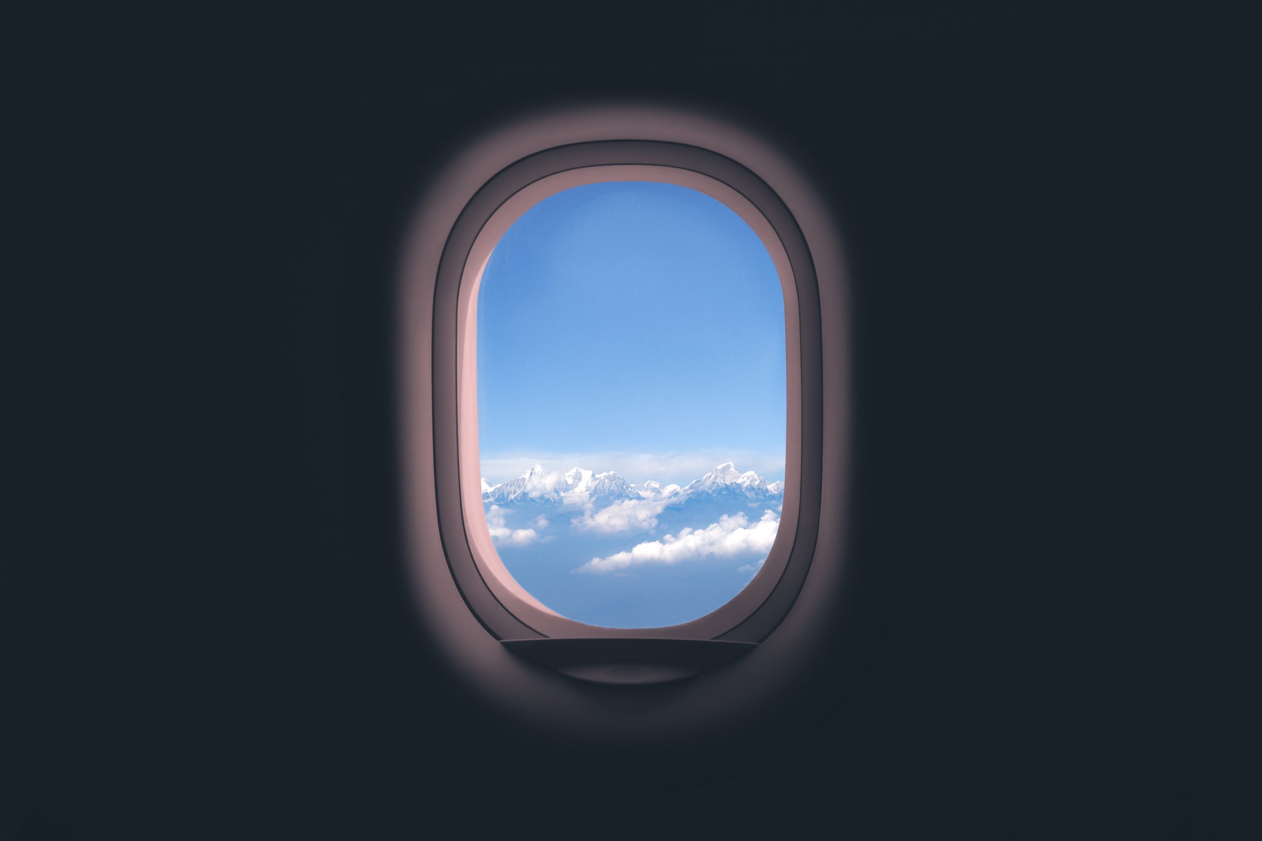 Airplane window. Mountain and clouds view